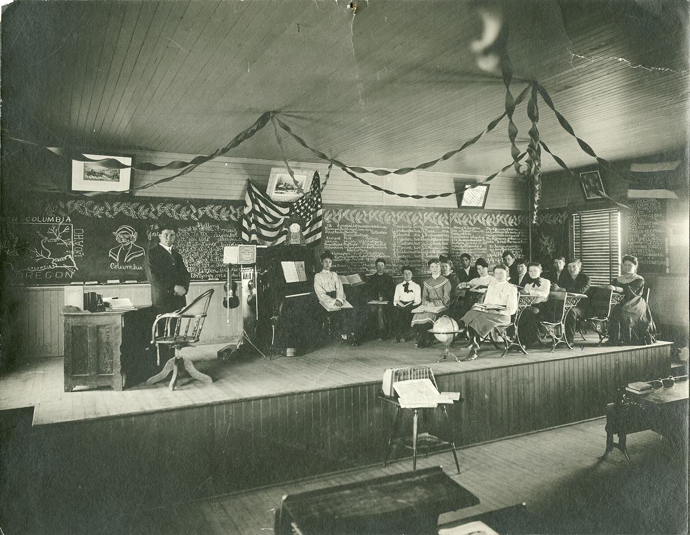 Un aula de hacia 1900 con alumnos sentados ante una pizarra